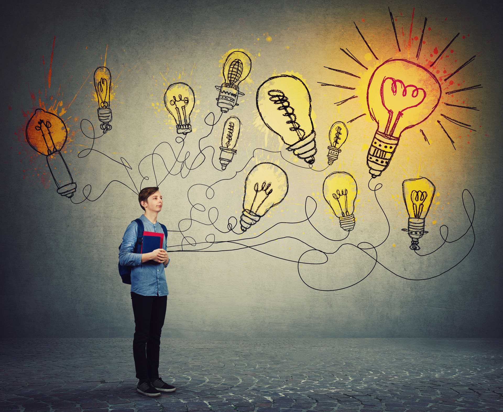 Student boy holding books and backpack imagining bright lightbulbs on the wall. Smart and ingenious teen guy has different thinking, genius creativity concept, alternative idea as the way to success.