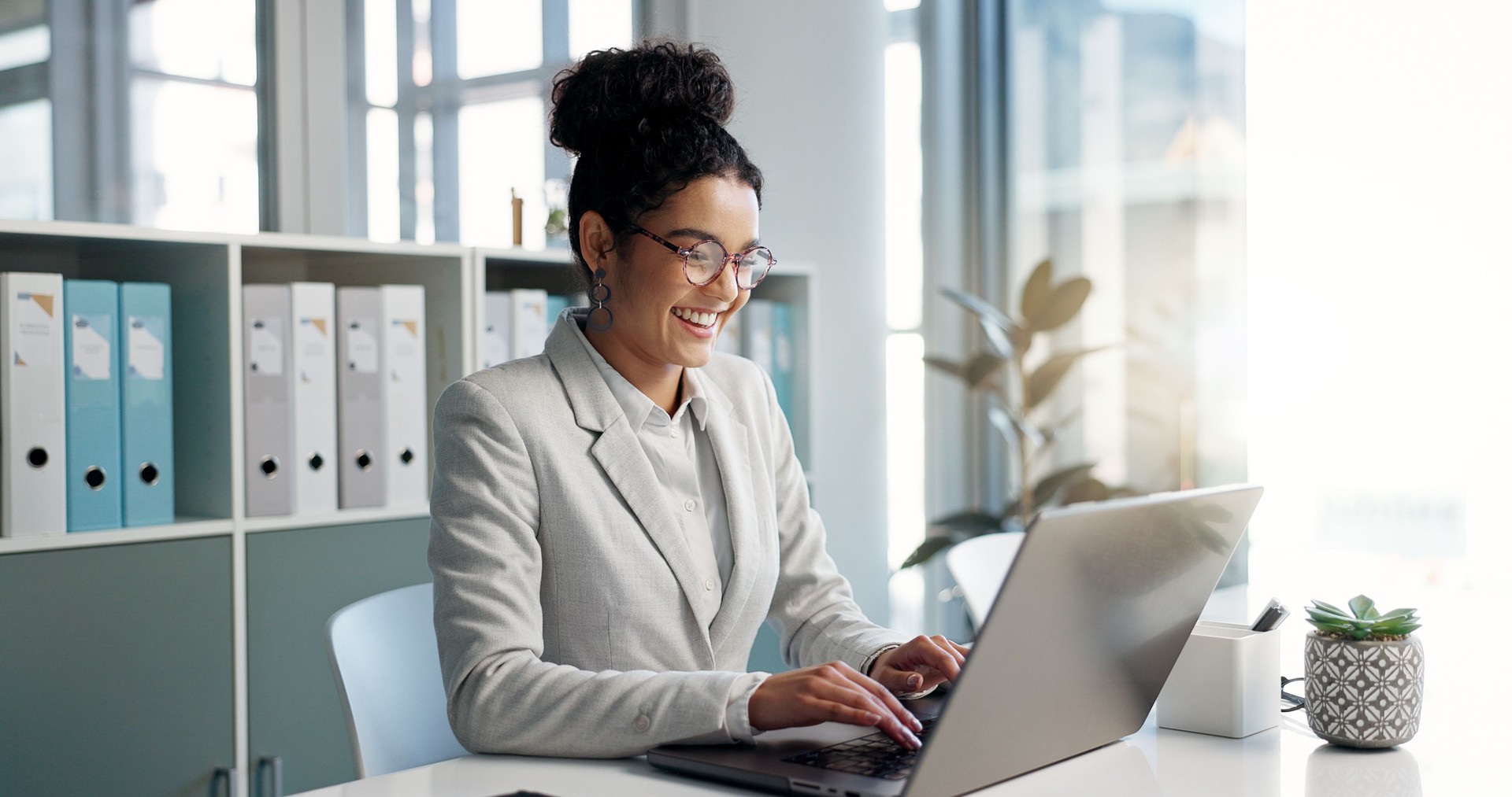 Happiness, laptop and typing government professional reading performance reports and audits. Corporate research, law firm and business lawyer working on compliance report.