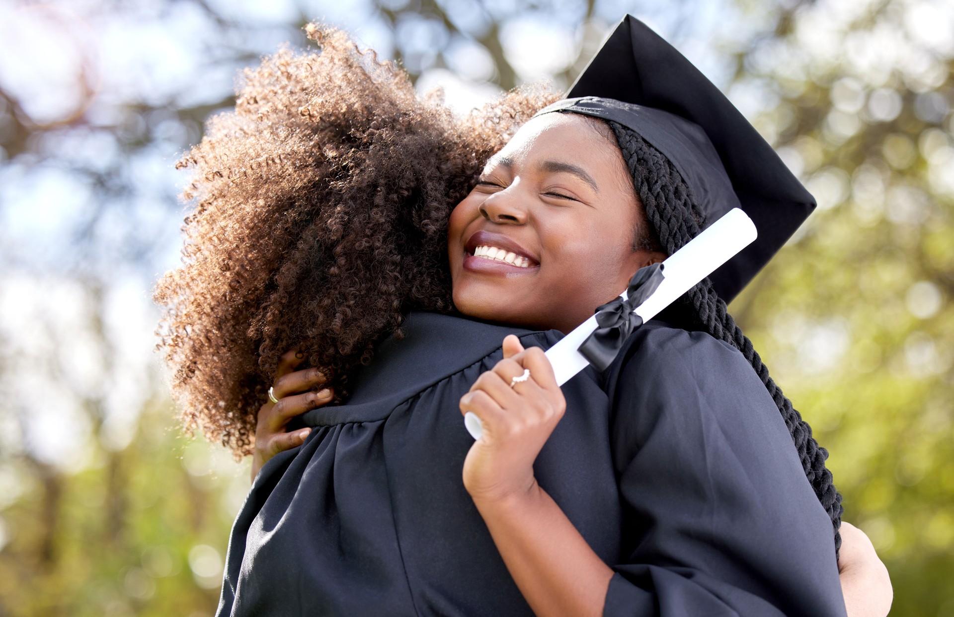 Shot of a woman hugging her student on graduation day after participation in GEAR UP and TRIO programs